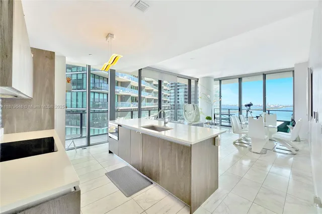 a large white kitchen with a large window and counter space