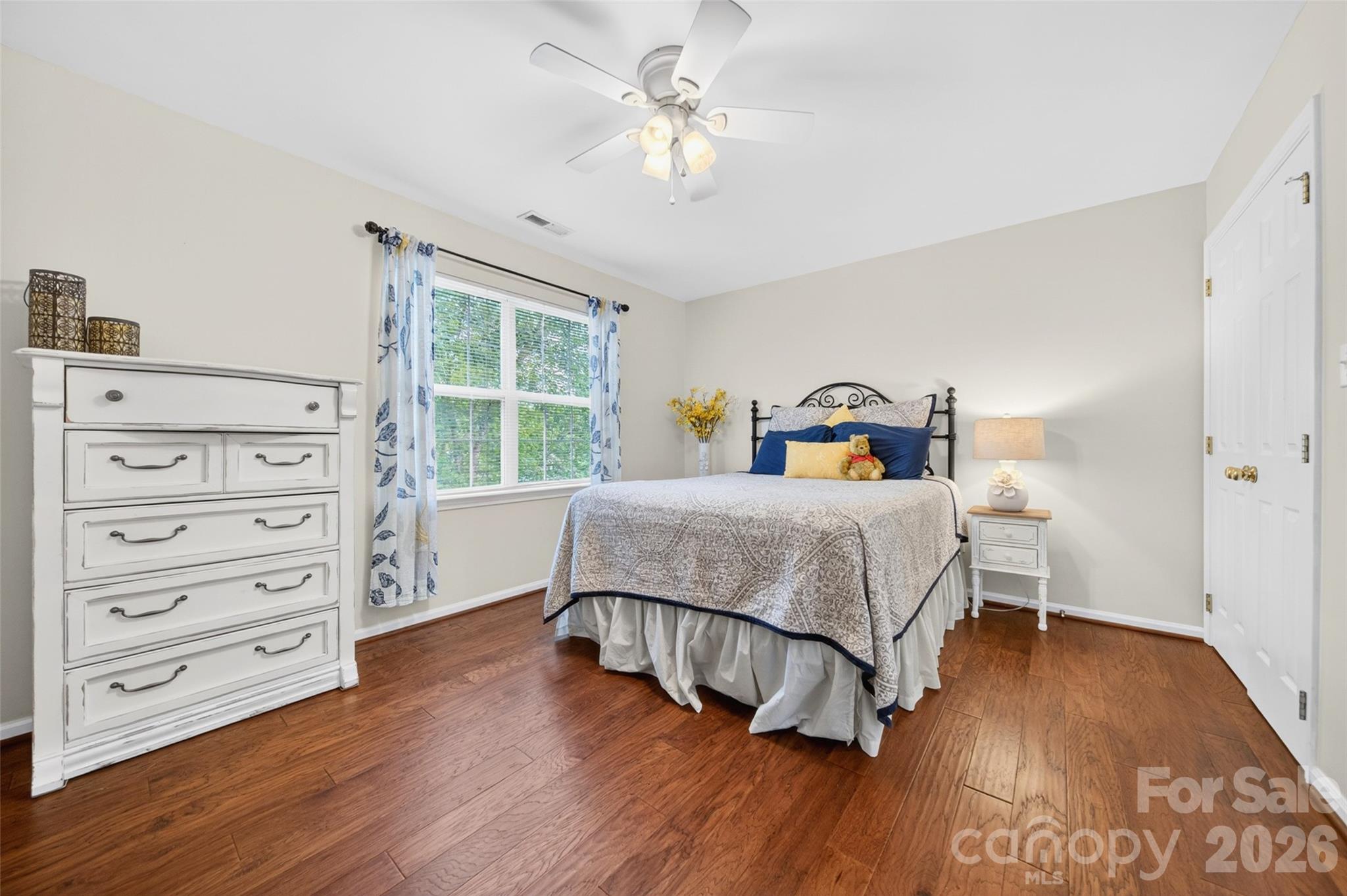 10502 Hellebore Road Charlotte, NC 28213 - Photo 25 of 48 a bedroom with a bed a dresser and wooden floor