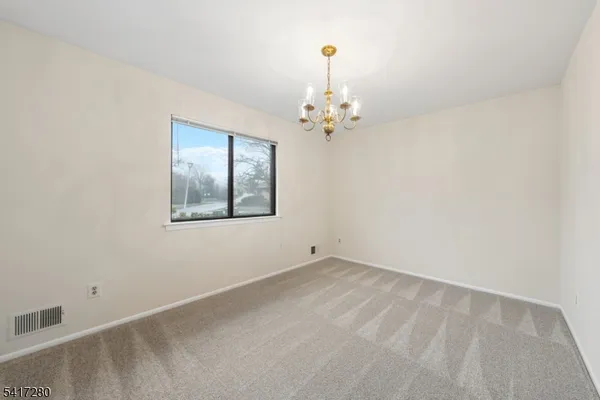a view of a chandelier in big room and a bathroom