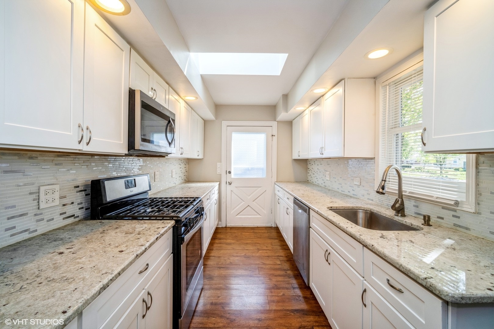 504 Isa Drive Wheeling, IL 60090 - Photo 2 of 13 a kitchen with stainless steel appliances granite countertop a sink stove microwave and cabinets