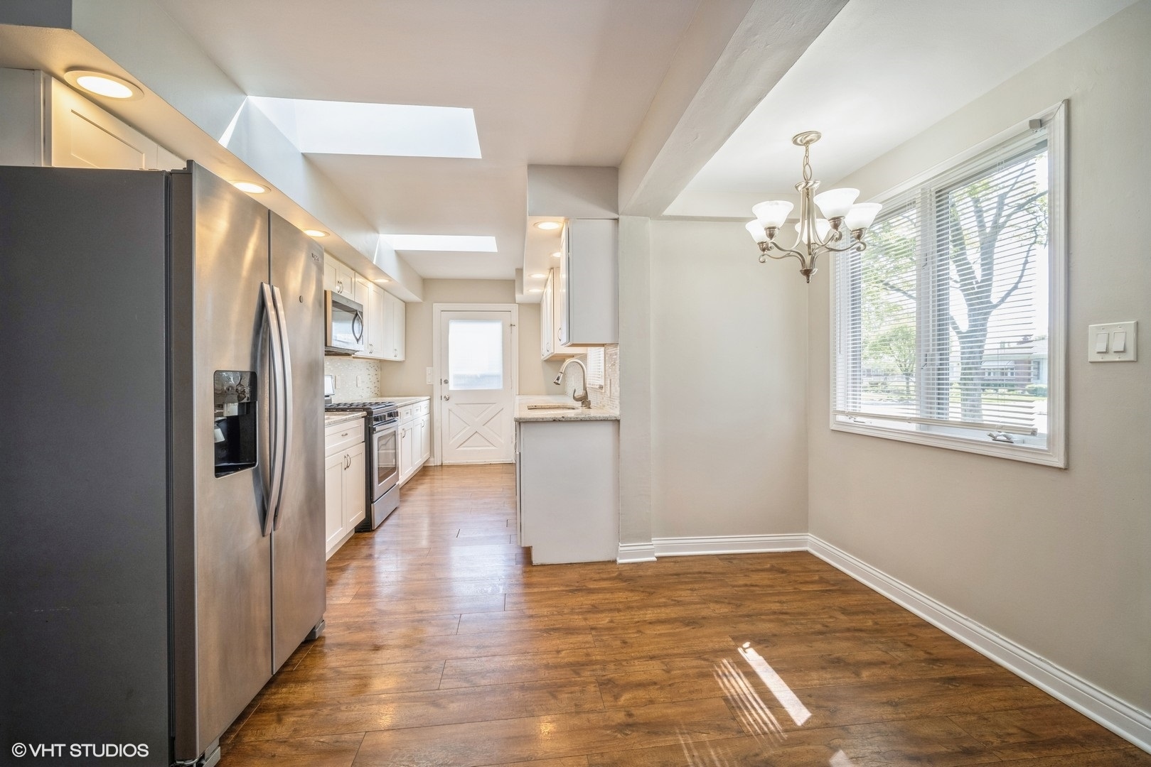 504 Isa Drive Wheeling, IL 60090 - Photo 3 of 13 a view of a hallway with wooden floor and a kitchen