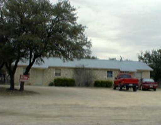 4911 Bell Springs Road Dripping Springs, TX 78620 - Photo 1 of 1 a front view of a house with a garden and parking