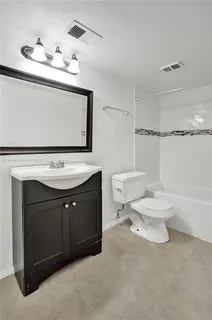 a bathroom with a sink vanity mirror and toilet