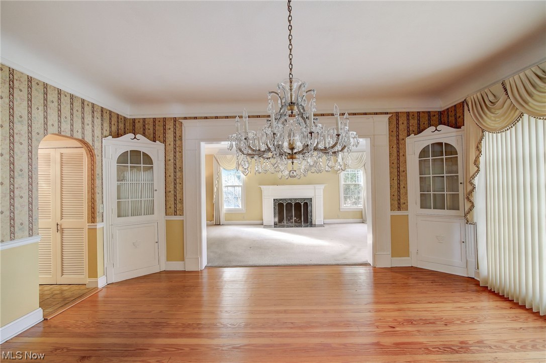 45555 North Ridge Road Amherst, OH 44001 - Photo 5 of 36 Unfurnished dining area with a wealth of natural light, light hard wood flooring, and an inviting chandelier