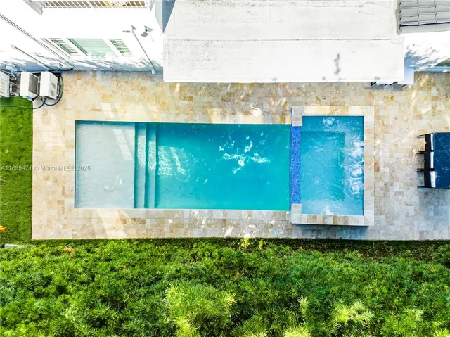 an aerial view of residential houses with outdoor space and parking