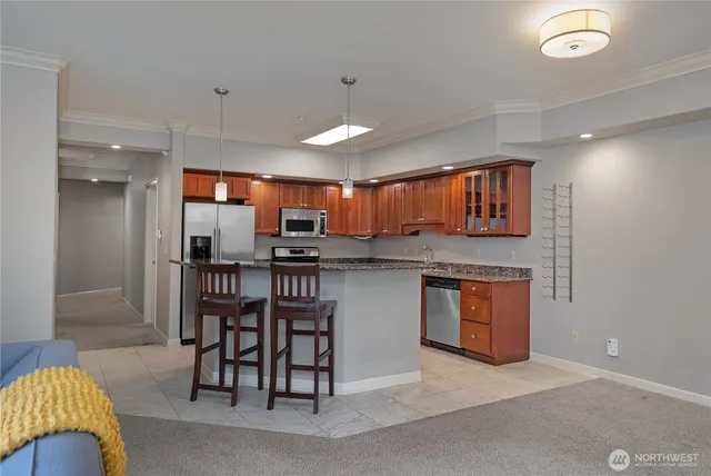 a kitchen with stainless steel appliances granite countertop a kitchen island a table and chairs in it