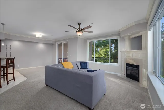 a living room with furniture a fireplace and a large window