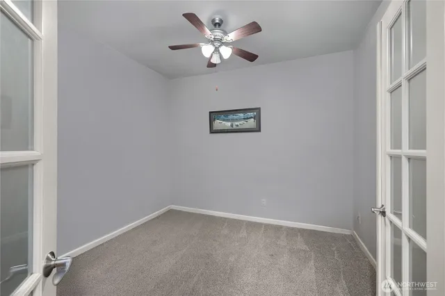 an empty room with a ceiling fan and a window