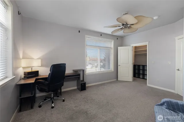 a view of a workspace with furniture and a window