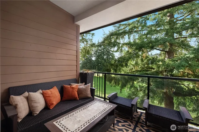 a balcony with wooden floor and outdoor seating
