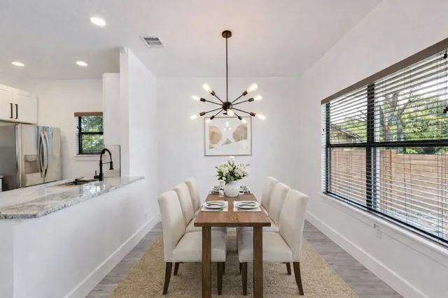 a dining room with furniture a chandelier and window