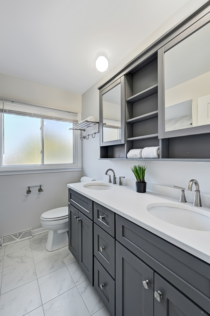 6725 Richmond Avenue Darien, IL 60561 - Photo 12 of 25 a bathroom with a granite countertop sink a toilet and a mirror