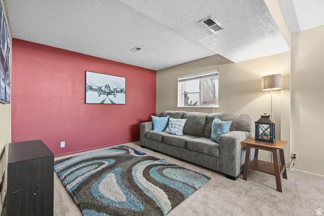 3951 Brixton Road Salt Lake City, UT 84129 - Photo 18 of 22 Carpeted room featuring a red accent wall, neutral painted walls, and a window providing natural light