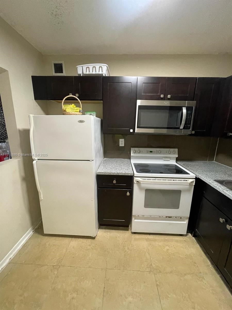 525 West 69th Street, Unit 209 Hialeah, FL 33014 - Photo 1 of 3 a kitchen with cabinets and stainless steel appliances