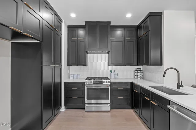 a kitchen with stainless steel appliances kitchen island granite countertop a refrigerator and a sink