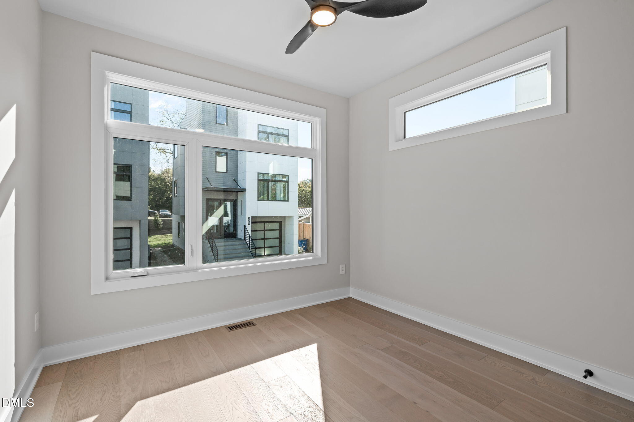 226 Woodsborough Place Raleigh, NC 27601 - Photo 9 of 42 a view of an empty room with wooden floor and a window