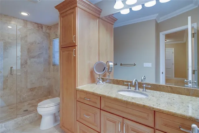 a bathroom with a granite countertop sink toilet a large mirror a shower and vanity