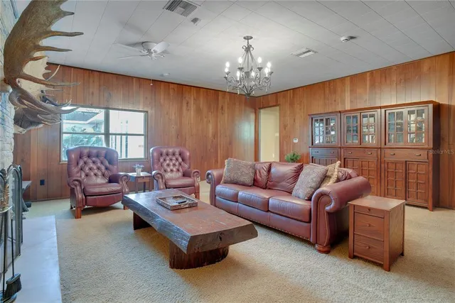 a living room with furniture chandelier and a large window
