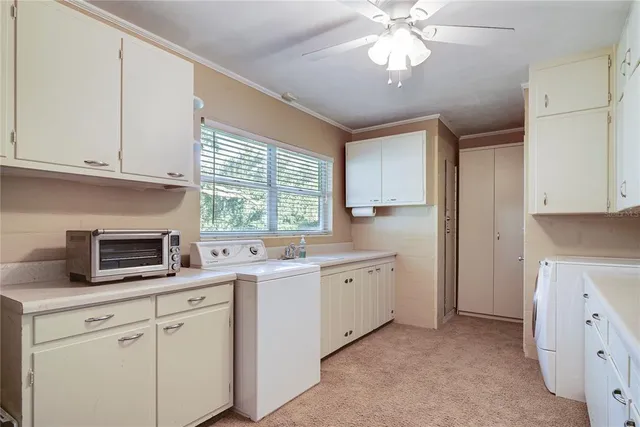 a kitchen with white cabinets and white appliances