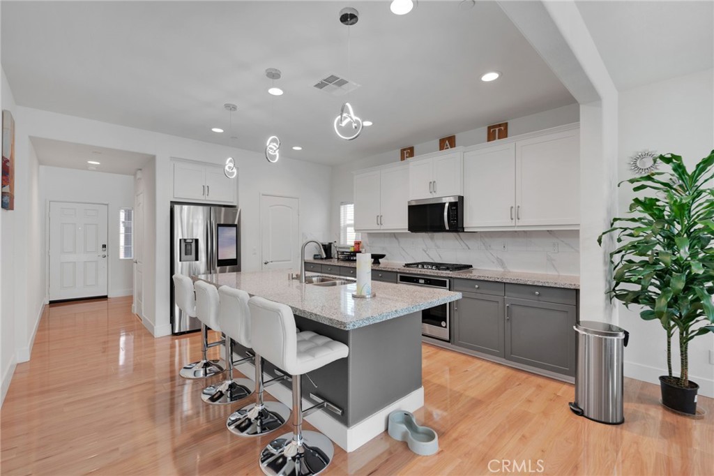 35153 Webb Place Beaumont, CA 92223 - Photo 11 of 42 a kitchen with white cabinets and stainless steel appliances