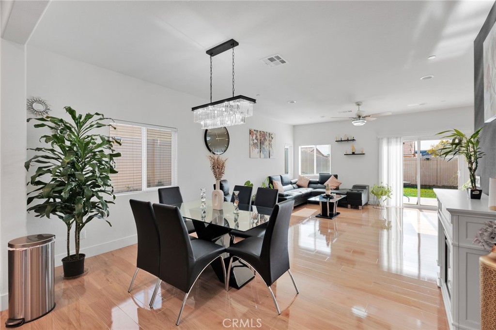 35153 Webb Place Beaumont, CA 92223 - Photo 12 of 42 a view of a dining room and livingroom with furniture wooden floor a chandelier