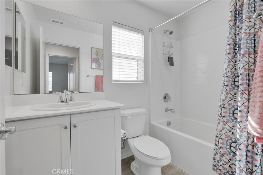 35153 Webb Place Beaumont, CA 92223 - Photo 23 of 42 a bathroom with a granite countertop sink toilet a large mirror a bathtub and shower