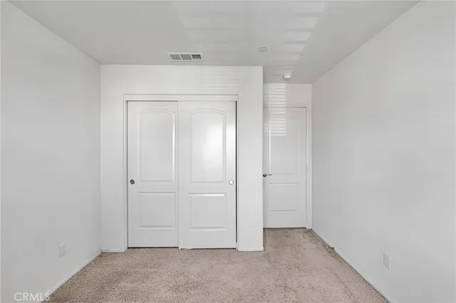 a bedroom with a bed television and a window