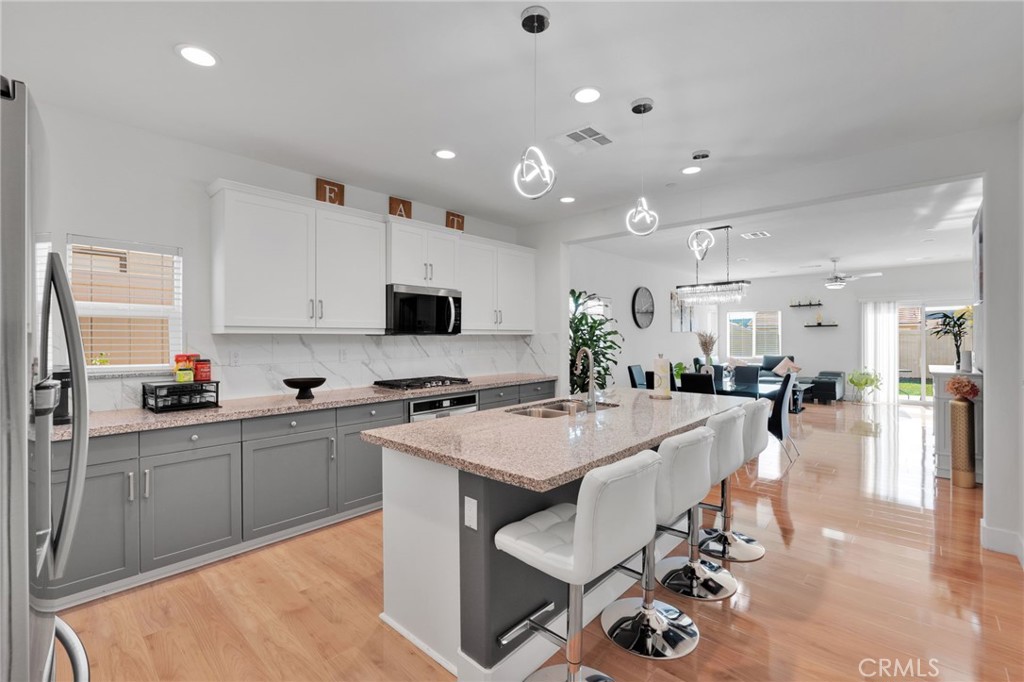 35153 Webb Place Beaumont, CA 92223 - Photo 7 of 42 a large kitchen with sink a center island stainless steel appliances and cabinets