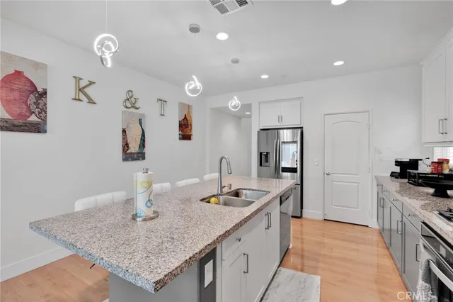 a kitchen with stainless steel appliances granite countertop a sink stove and refrigerator