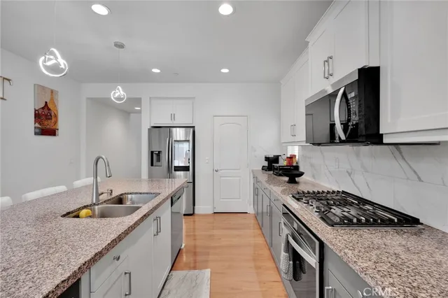 a kitchen with white cabinets and stainless steel appliances