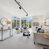 a living room with furniture and a large mirror next to a window