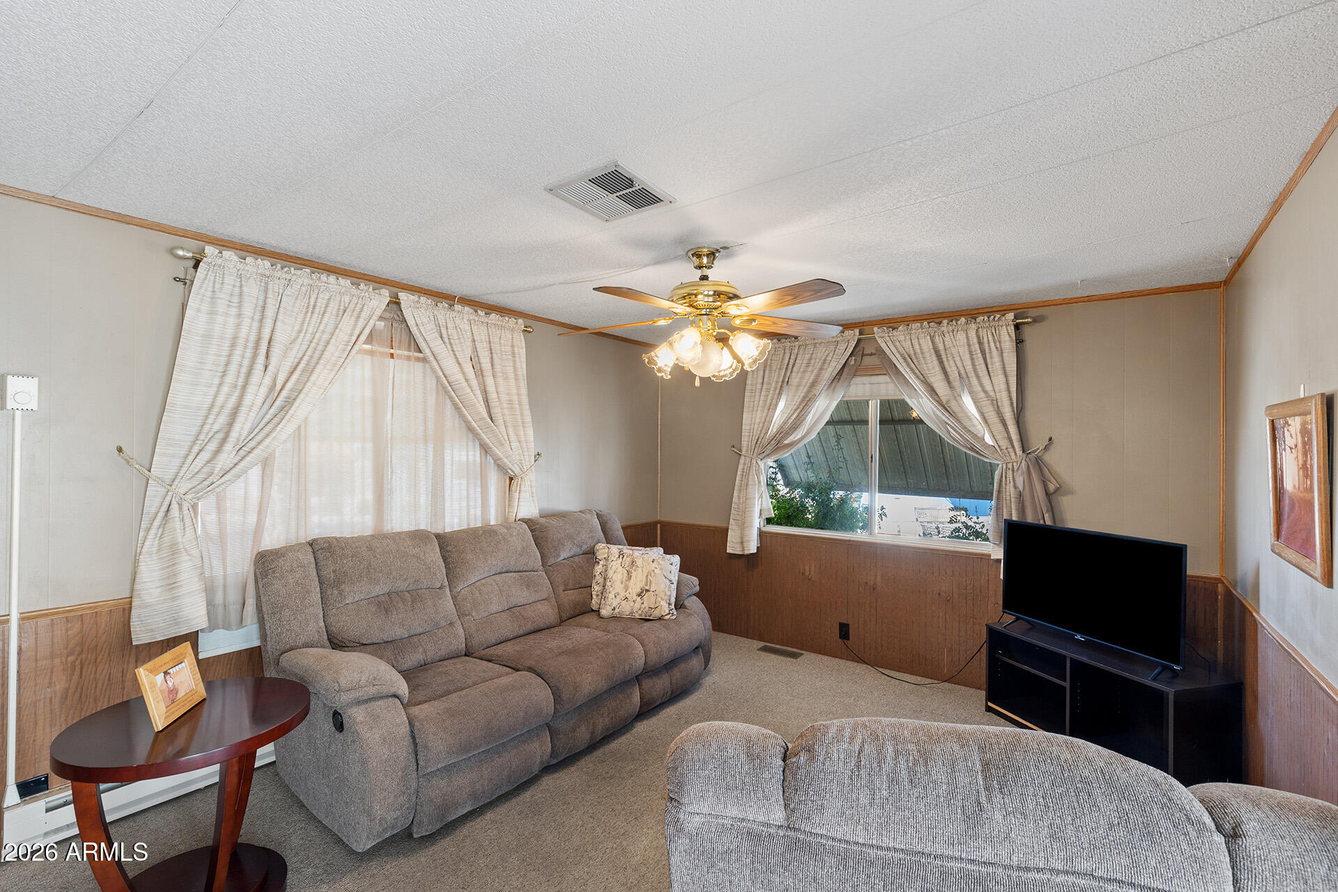 10540 East Apache Trail, Unit 151 Apache Junction, AZ 85120 - Photo 19 of 31 a living room with furniture a large window and a flat screen tv