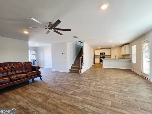 a living room with furniture and a ceiling fan