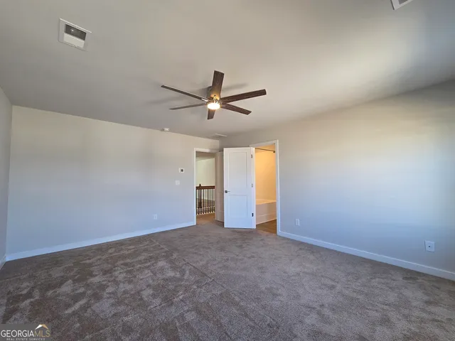 an empty room with closet and windows