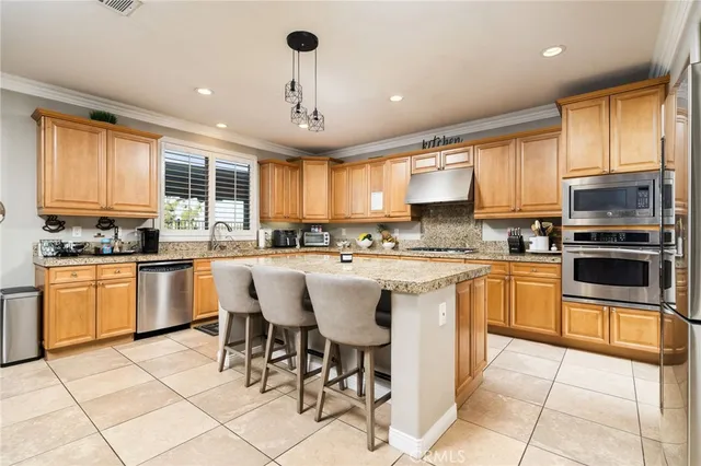 a kitchen with stainless steel appliances granite countertop a refrigerator a stove and a sink with granite countertops