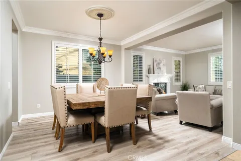 a dining room with furniture a chandelier and wooden floor
