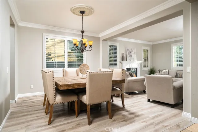 a dining room with furniture a chandelier and wooden floor