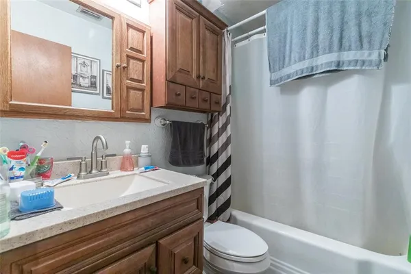 a bathroom with a granite countertop toilet sink and mirror