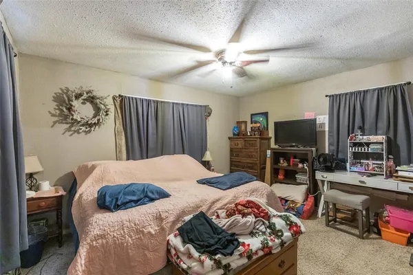 a bedroom with a bed and a flat tv screen on dresser