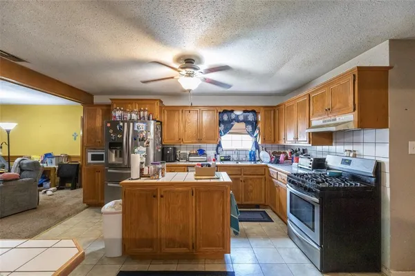a kitchen with a stove window and cabinets