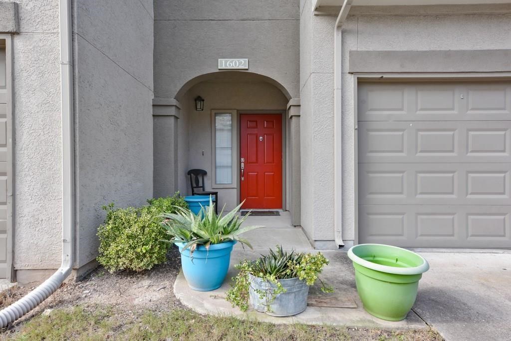 11203 Ranch Road 2222, Unit 1602 Austin, TX 78732 - Photo 1 of 25 a front view of a house with potted plants