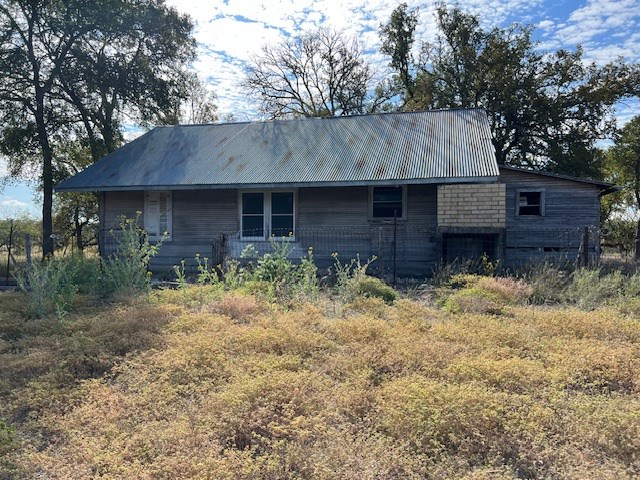 800 Schumann Road Stonewall, TX 78671 - Photo 16 of 27 a backyard of a house with wooden fence and a tree