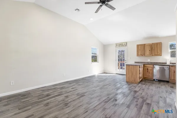 a view of a kitchen with wooden floor and electronic appliances