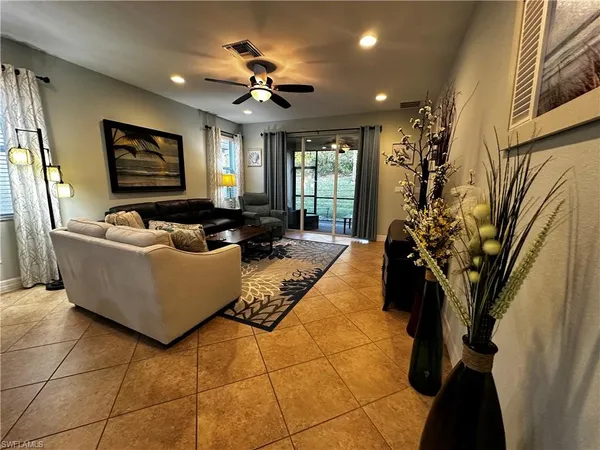 a living room with couches a flat screen tv and a potted plant