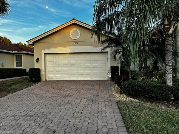 a front view of house with yard and trees around