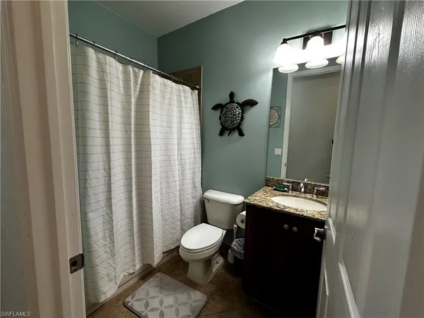a bathroom with a toilet a sink and shower curtain