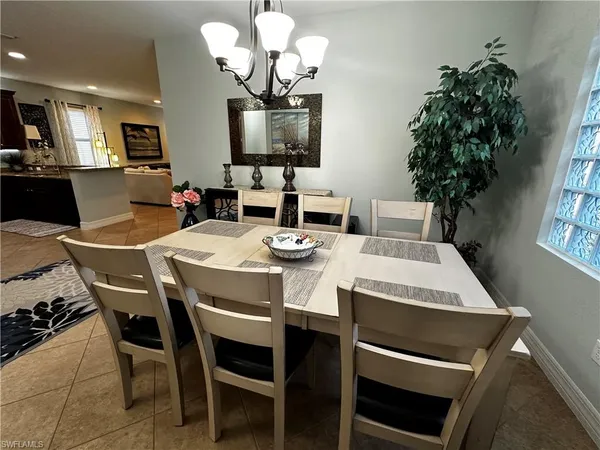 a view of a dining room with furniture a chandelier and wooden floor