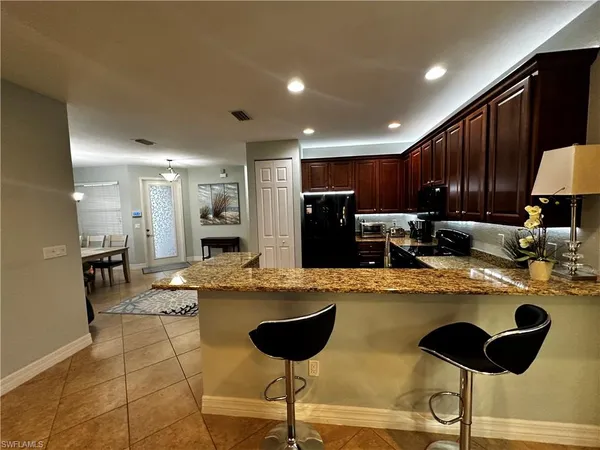 a kitchen with refrigerator and chairs