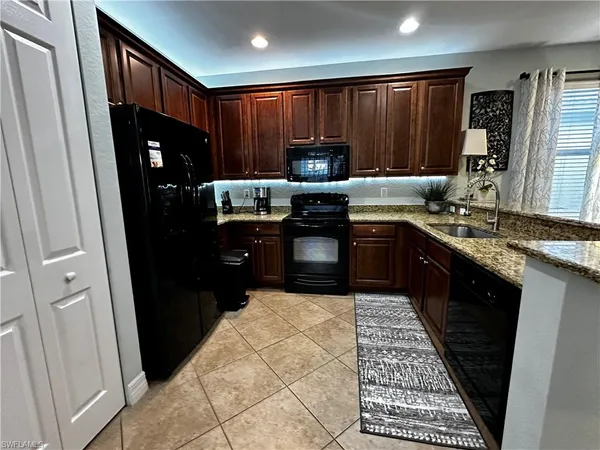a kitchen with stainless steel appliances granite countertop refrigerator stove and sink