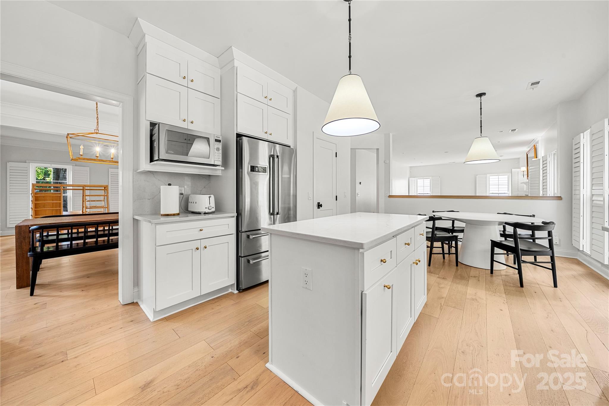 8500 Headford Road Charlotte, NC 28277 - Photo 16 of 47 a kitchen with stainless steel appliances a stove a sink a dining table and chairs with wooden floor